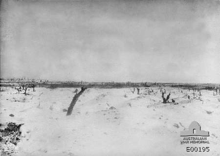 Image of The battlefield of Pozieres, in France, west of the village, south of Bapaume Road, looking towards High Wood. The black smoke of an enemy barrage shows against the snow in the distance.