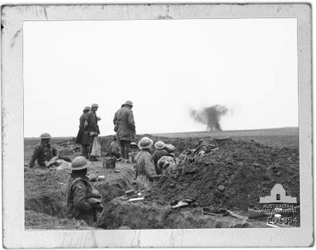 Image of Soldiers in a trench watch a shell bursting near the reserve trenches occupied by the 51st Battalion in front of Lavieville, in France.