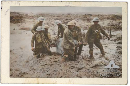 Image of "Somme Mud, Winter, 1916". Hand-coloured print of a photograph taken by a British Ministry of Information photographer during the battle of Pilckem Ridge, 31 July - 2 August 1916 (IWM Q 5935): seven stretcher-bearers carry a casualty through knee-deep mud.